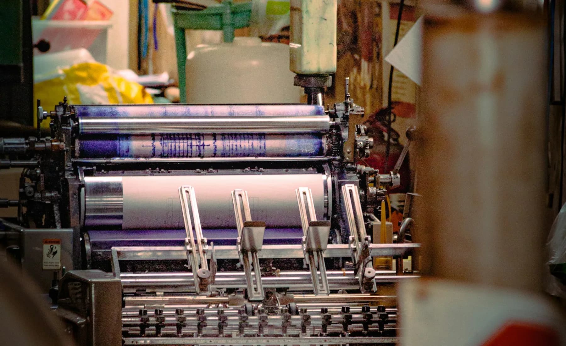 Máquina de impressão em operação, aplicando cor em uma bobina de papel
