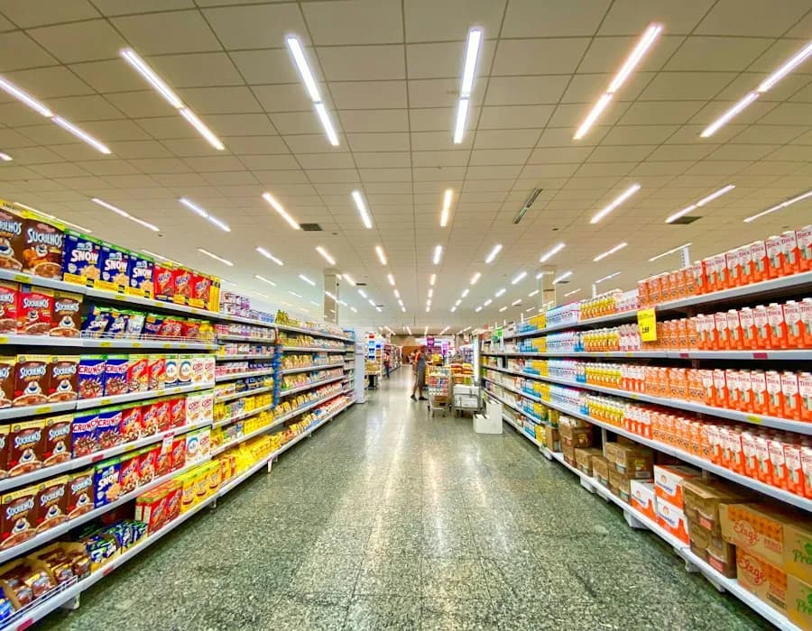 Corredor de supermercado com prateleiras abastecidas e etiquetas de preço