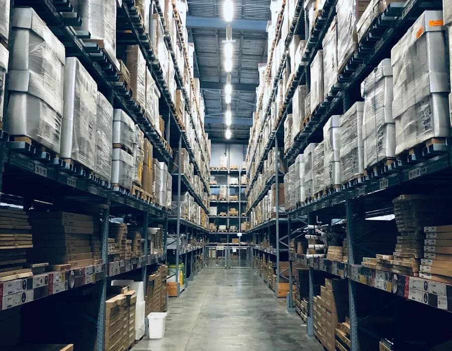 Corredor de centro de distribuição com paletes empilhados em estruturas porta-paletes